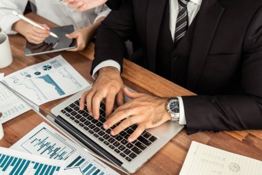 Ofis masasındaki finansal veri raporlarını analiz eden çeşitli bir grup iş analisti. Stratejik pazarlama planlaması için iş zekası analizi çizelgesi ve grafiği.
