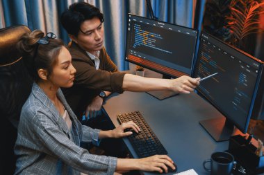 Bilgi teknolojisi geliştiricileri modern ofisteki neon ışık odasında verileri çevrimiçi olarak çalıştıran akıllı web sitesi geliştirme kodlayıcı sistemine işaret ediyorlar. İnfobahn.