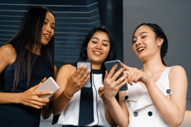 Üç kadın arkadaş ellerinde cep telefonuyla sohbet ediyorlar. Sosyal medya, dedikodu haberleri ve online alışveriş kavramı. uds