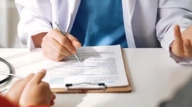 Hastanedeki doktor masasında oturup hasta test sonuçlarını teşhis eden, hastalıklar ve hastalıklar için tedavi planı geliştiren evrak işleriyle uğraşıyor. Sağlık personeli ve sağlık hizmetleri. Ağır çekim. Katı.