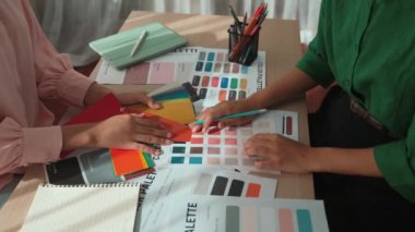 Grafik tasarımı için renk seçimi yapan ve beyin fırtınası yapan iki tasarımcının yavaş çekim çekimi ya da tasarım bürosunda kromatik danışmanlık hizmeti isteyen bir müşteri. Değiştirilmiş