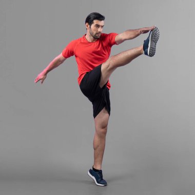 Vücut uzunluğunun tamamı atletik ve sporcu genç bir adamın kardiyo egzersizinde, izole edilmiş arka planda tekme pozisyonunda. Sağlıklı aktif ve vücut bakımı yaşam tarzı.