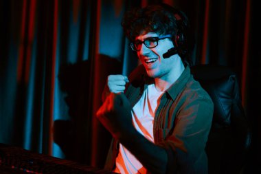 Genç oyun flaması takımı, Esport ile birlikte neon ışıklı odada kulaklık takarak online dövüş kazanan oyuncuları topluyor. Bir sonraki seviyeye rakip kazanmak için strateji planı uyguluyorum. Toplayıcı.