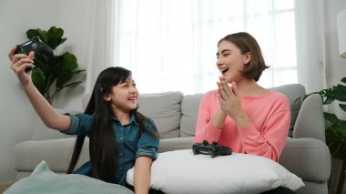 Mutlu çocuk oyun oynuyor ve oturma odasında otururken annesini kazanıyor. Çekici kız elini havaya kaldırıp şarapları kutlarken beyaz bir anneyle vakit geçiriyor. Pedagoji.