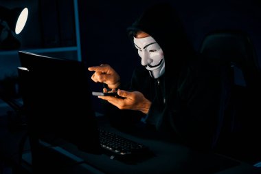 Beyaz gülümseyen isimsiz suçlu maskesi kurbana sesleniyor, kişisel bilgileri hacklemeye ikna ediyor, veri sunucu sistemindeki bilgisayar korsanlarının kullandığı şifreleme programını paylaşıyor. Tahmin et..