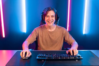 Kazanmak için çevrimiçi oyun oynayan akıllı flama makinesinin sunucu kanalı, neon ışıklı odada seçilen takım yarışması için izleyicilerle birlikte canlı yayında canlı yayında kulaklık takıyor. Bireysel.