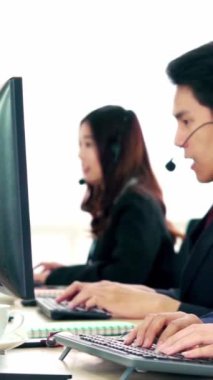 Ofiste çalışan kulaklık takan işadamları uzak müşteri ya da meslektaşlarını desteklemek için çalışıyorlar. Arama merkezi, tele pazarlama, müşteri destek acentesi telefon görüşmesinde hizmet sunar.