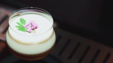 Tutkulu meyve suyu bardağında dönüşümlü, özel, ferahlatıcı, pembe çiçekle süslenmiş, lüks gece klübünde gece hayatı karışımı sergilenen bir içecek. Vinosity.