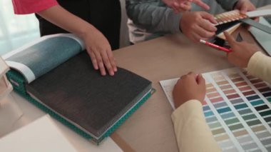 Mimari ekipman kullanarak yavaş çekim ev tasarımcısı bir plan çizerken, iç mimari tasarımcı da müşterilerin talebine göre renk örneklerinden uygun renkler seçiyor. Değiştirilmiş