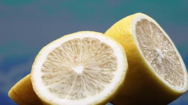 Bir dilim taze limon, parlak sarı ve canlı bir kalite, açıkta duruyor. Serinletici bir sıvıyla parlayan et, parçalanmış iç organlarını ortaya çıkarır. Turunçgillerin canlılığının özü. Geliştirilebilir.