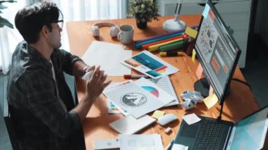 Toplantıda profesyonel tasarımcı yazma ve logo grafiği tasarlama. Renkli paletler üzerinde çalışan iş adamlarının yakınlaşması ve masaya kağıt ve ekipman ile yapışkan notlar yazmak. Sempozyum.