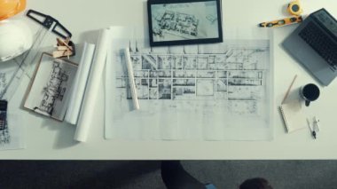 Güvenlik kaskı, dizüstü bilgisayar ve ekipmanlarla başarılı bir proje için toplantı masasında el kaldırırken cep telefonu kullanarak yöneticiyle konuşan yetenekli mühendisin alt görüşü. Hizalama.