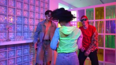 Genç İspanyol dansçı gece kulübünde dans ederken kameraya bakıyor. Serbest stil müzik eşliğinde dans eden profesyonel sanatçı çok kültürlü hipster ya da çeşitli arkadaşlar tarafından destekleniyor. Mutluluk.