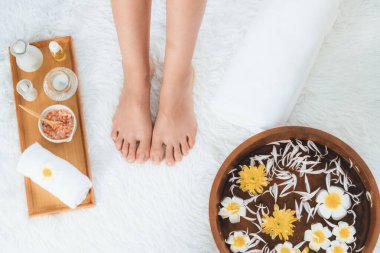 Panorama üstteki kadın lüks spa salonunda mutlu bir ayak masajı yaparken, masör de hafif gündüz atmosfer tesisinde veya otel ayak spasında refleksoloji terapisi uyguluyor. Sessiz.