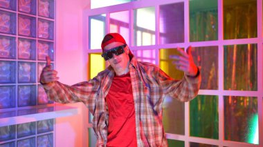 Kafkas dansçısı dans ederken çeşitli arkadaşları gece kulübünde neon ışıkta ayak seslerine bakıyor. Çoklu etnik kökenli hipsterin serbest stil müziğe geçişi ve mutlu bir adamın kameraya bakışıyla. Mutluluk.