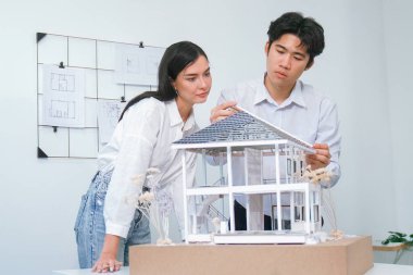 Kooperatif mühendis ekibinin portresi ev modelini ölçmek için cetvel ve mimari ekipmanlar kullanarak birlikte çalışıyor. Yaratıcı iş tasarımı ve takım çalışması konsepti. Tertemiz...