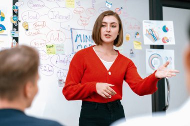 Profesyonel çekici kadın lider, modern iş toplantı odasında beyin fırtınası zihin haritalama istatistikleri ve renkli yapışkan notlar kullanarak yaratıcı pazarlama planını sunuyor. Tertemiz..