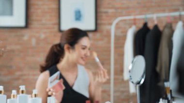 Kadın nüfuzlu kişi canlı yayın yapan video görüntülerini sosyal medya ya da blog üzerinden gözden geçiriyor. Kozmetik stüdyosu ışıklandırmalı mutlu genç kız çevrimiçi pazarlama oturumu yayını için..