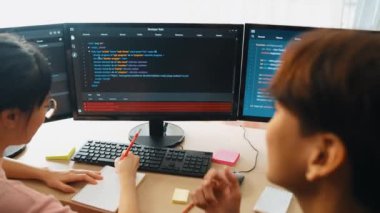 Yavaş çekim arkası yazılım geliştirici mühendisi bilgisayar programlama için birlikte çalışarak hata ayıklama kodunu çözüyor, ofiste monitörde karmaşık algoritmaları çözüyor. Filizlenen