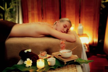 Lüks spa salonlarında sıcak mum ışığında cilt bakımı yaptıran kadın müşteri. Sağlık Spa vücut fırçasında tuz temizleme güzellik tedavisi. Sessiz.