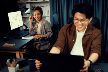 Ortağıyla birlikte gülen işkadını tüccarı sıradan bir takım elbise içinde borsa alışverişini tartışıyor, geceleri en yüksek kar getiren ticari değer olan finansal teknoloji yatırımını elde ediyor. İnfobahn.