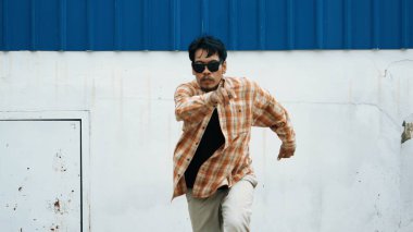 İspanyol komedi koreografı hip hop tarzında dans ediyor. Genç mutlu break dansçı B-boy dansı yapıyor. Sokak dansı yapan komik adamın hareket çekimi. Açık hava sporu 2024. Modern dans. hiphop.