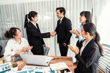 Bir grup iş adamı başarılı bir iş anlaşması toplantısı yaptıktan sonra el sıkıştı. Çeşitli yarış bürosu çalışanları şirket ofisinde pazarlama planlamasında ilerleme kaydettikten sonra kutlama yapıyorlar. Çok titiz.