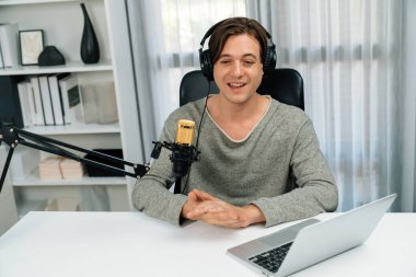 Sunucu kanalı, gülümseyen akıllı yayıncı kaydı, senaryosu ve akıllı telefonuyla sosyal medyada sohbet programı, kulaklık takarak modern ev stüdyosundaki video flamalarını kaydediyor. Bireysel.