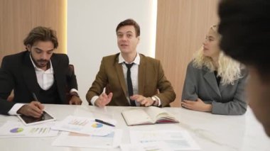 Çeşitli ofis çalışanları, işyerindeki iş sinerjisini ve üretken takım çalışmasını sembolize eden süslü ofis odasında el ele tutuşuyorlar. İş çalışanları arasındaki işbirliği ve birlik.