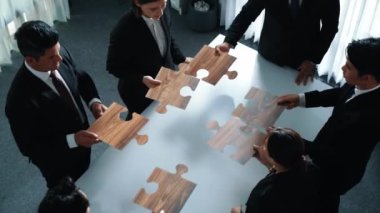 İş adamlarının toplantı odasında yapboz yapmaları. Profesyonel pazarlama ekibi yapboz parçalarını toplarken masada duruyor. Birlik, işbirliği ve ekip çalışmasını göster. Müdürlük.