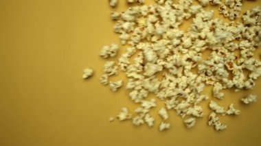 Patlamış mısırın yavaş çekim sahnesi sarı arka plandaydı. Taze patlamış mısırlar hareket ediyor ve düşüyor. Büyüleyici bir dansta hareket halindeki patlamış mısır. Dinamik hareket ve enerji. Geliştirilebilir.