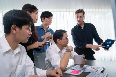 Bir grup farklı ofis çalışanı şirket ofis odasında stratejik iş pazarlama planlamasında birlikte çalışıyor. İş yeri konseptinde pozitif takım çalışması. Tedbirli