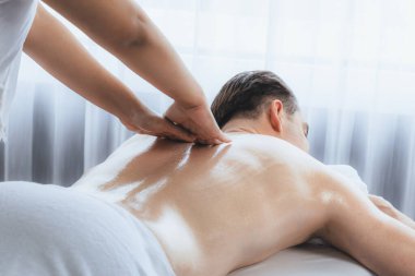 Kafkas erkek müşteri stres önleyici spa masajının keyfini çıkarıyor ve lüks otel veya oteldeki gündüz açık hava ortamında güzellik derisi eğlencesi ile şımartıyor. Sessiz.