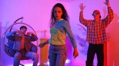 Çekici mutlu dansçı kameraya bakarken zeki kadın neon ışıkla kafiyeli hareket ediyor. Profesyonel İspanyol şarkıcı çeşitli arkadaşlarıyla renkli kıyafetler giyerken break dans yapıyor. Mutluluk.