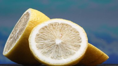 A slice of lemon, bright yellow and vibrantly citric, lies exposed. The yellow flesh, with refreshing juice, reveals its segmented interior. The essence of citrus vibrancy. Slow motion. Comestible. clipart