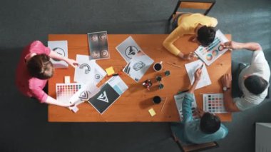 Proje yöneticisi renk paletleri seçerken tasarımcının tablete baktığı yukarıdan aşağıya hava görüntüsü. Profesyonel grafik tasarımının en üst görüntüsü ve logoya bakın. Yetenekli ekip grafikleri seçiyor. Sempozyum.