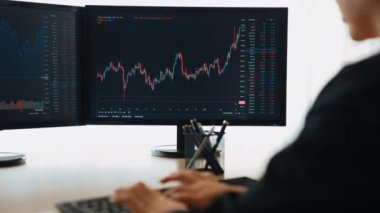 Menkul kıymetler borsası pazarlamasını inceleyen borsa yatırımcıları, zarar ve kazanç için mum bar fiyatlarını analiz eden monitörlere bakıyor. Filizlenen