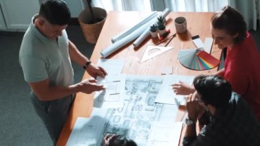 Proje yöneticisi çalışırken ve kahve içerken iç mimari planlama binasının üst görüntüsü. Bir grup mühendis fikir üretiyor ve fikir sunarken ev yapısını tasarlıyor. Sempozyum.