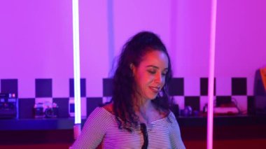 Stüdyoda mor ışıkla sokak dansı yapan İspanyol sokak dansçılarına yakın çekim. Profesyonel sanatçı şık kumaşla enerjik bir hareket sergiler. Çılgın, komik. Yarı vücut. Mutluluk.