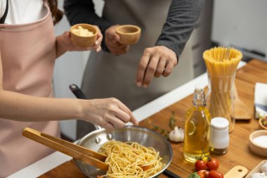 El aşçıları spagetti karışımı pişirerek tavaya baharat ve lezzetli sos koyarak ev yapımı yemek sunma kavramını geliştirir. Varsayım.