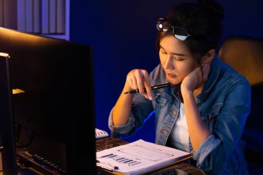 Genç ve güzel Asyalı iş kadını evrak işleri ile ilgili pazar raporunu analiz ediyor, iş planını düşünüyor ve gece vakti neon ışıklı ofiste yeni bir strateji projesi yaratıyor. Taktik.