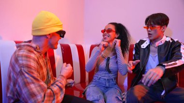 Mutlu kız kameraya bakıyor ve kanepede otururken pop müzik dinliyor. İspanyol kadın serbest stil dans ederken kameraya bakıyor neon ışıkta çeşitli arkadaşlarla dans ediyor. Mutluluk.