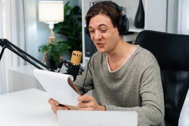 Akıllı yayıncının sunucu kanalı canlı sosyal medya yayını ile dinleyicilere senaryo okuyarak, kulaklık takarak modern ev stüdyosundaki video flamalarını kaydediyor. Bireysel.