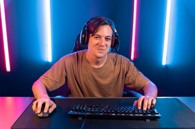 Kazanmak için çevrimiçi oyun oynayan akıllı flama makinesinin sunucu kanalı, neon ışıklı odada seçilen takım yarışması için izleyicilerle birlikte canlı yayında canlı yayında kulaklık takıyor. Bireysel.