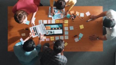 Web tasarımı için birlikte çalışan iş adamlarının üst düzey görüşü. Tasarımcı beyin fırtınası yapan ve web sitesi arayüzü hakkında tartışan ve dijital tasarım ile tablete bakan hava görüşü. Sempozyum.