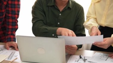 Akıllı mimar ve güvenlik mühendisi, mimari belge, ölçüm araçları ve ahşap blokların modern ofiste etrafa saçıldığı masa planlarını tartışıyor. - Yakın çekim. Tanımlama.