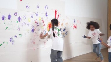 Beyaz arka planda renkli ellerle oynayan ve koşan oyuncu çocuklar. Komik, mutlu, çok kültürlü öğrenciler sanat dersine katılmayı severler. Yaratıcı aktivite konsepti. Etkinlik.