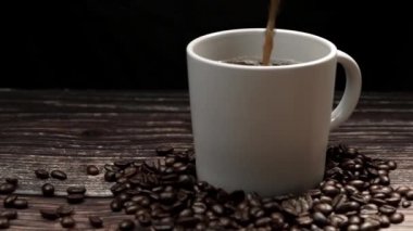 Kahve makinesi fincana siyah arka planda aromatik sıcak kahve dolduruyor. Sıcak kahve ya da espresso beyaz kahve bardağına dökülüyor ve kaynamış suya dökülüyor. Geliştirilebilir.