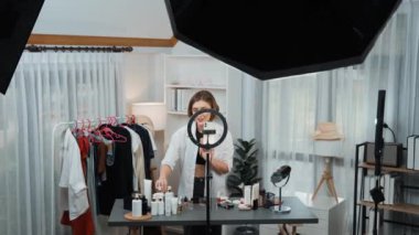 Kadın nüfuzlu kişi video görüntülerini canlı yayınlıyor. Kıyafetler sosyal medyada ya da blogda yer alıyor. Stüdyo ışıklandırmalı mutlu genç kız çevrimiçi pazarlama oturumu yayını için..