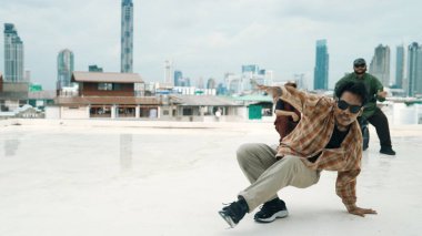 Çatıda çok kültürlü arkadaşlar varken profesyonel İspanyol break dansçısı B boy dansı. Genç modern dans grubu hip hop hareketi yapıyor. Tarz, moda, aksiyon. Açık hava sporu 2024 hiphop..